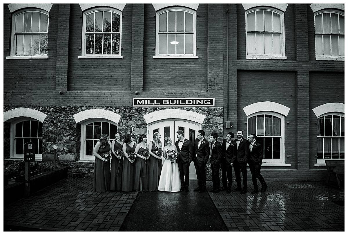 Wedding party group portrait taken outside the Thomas Kay Woolen Mill building.