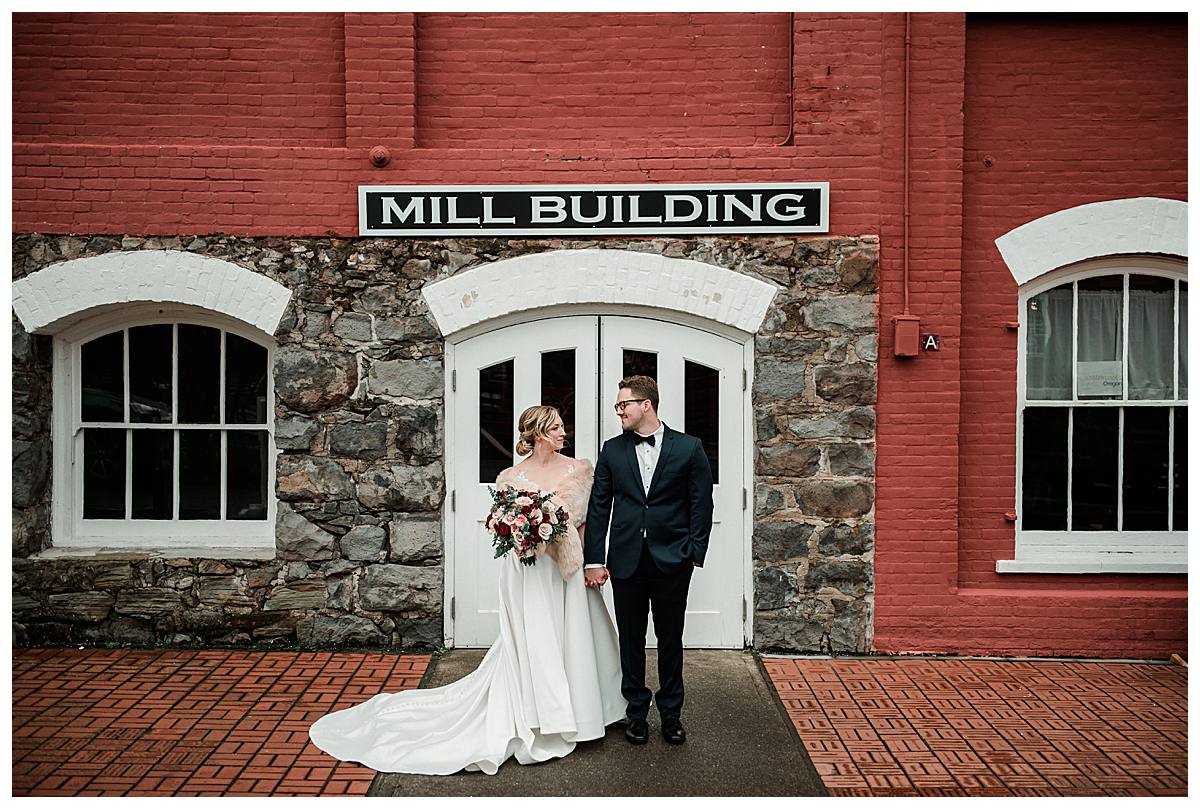 Bride and groom image standing outside the main doors of the Thomas Kay Woolen Mill building at the Willamette Heritage Center